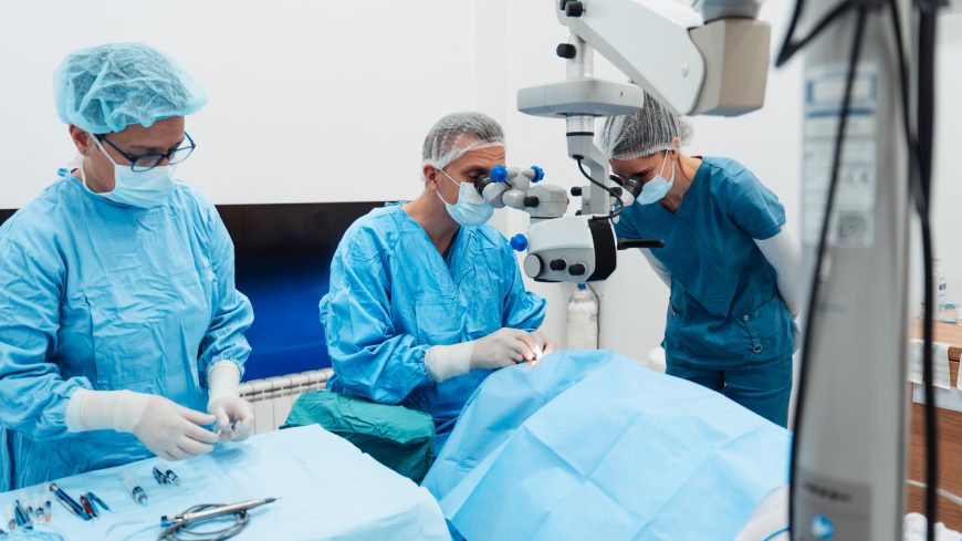Skilled surgeon and his medical team performs precise eye surgery on an elderly patient, restoring vision with latest medical technology and cutting-edge techniques. Modern eye surgery concept.