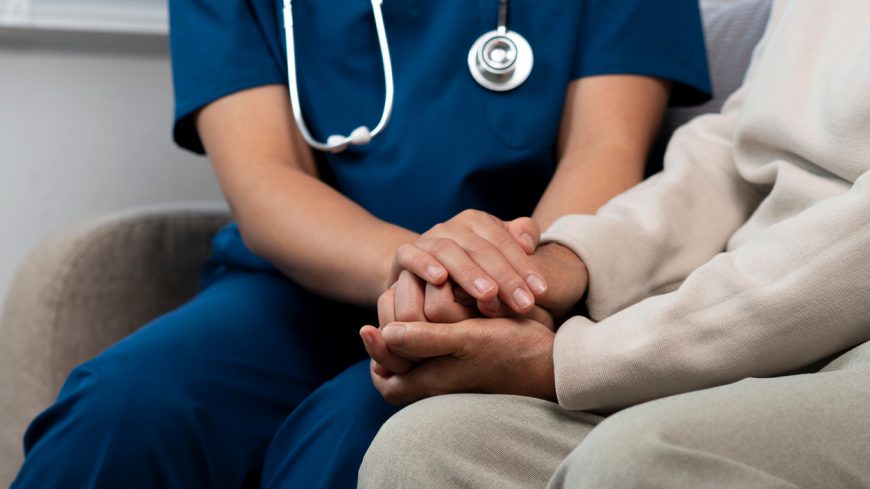 A female nurse caregiver holds hands to encourage and comfort an  people of retirement age Caregiver helping elderly woman provides medical advice